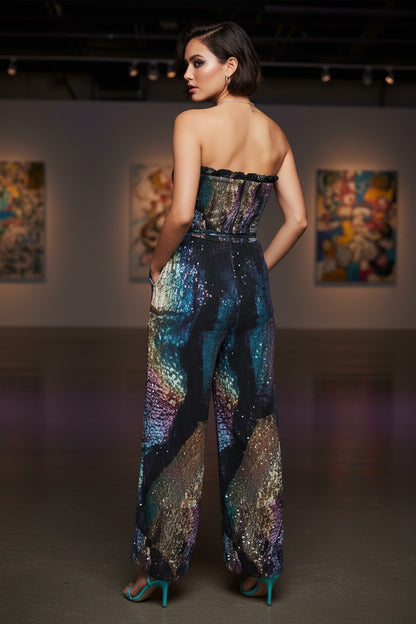 Woman wearing a colorful strapless jumpsuit in an art gallery setting