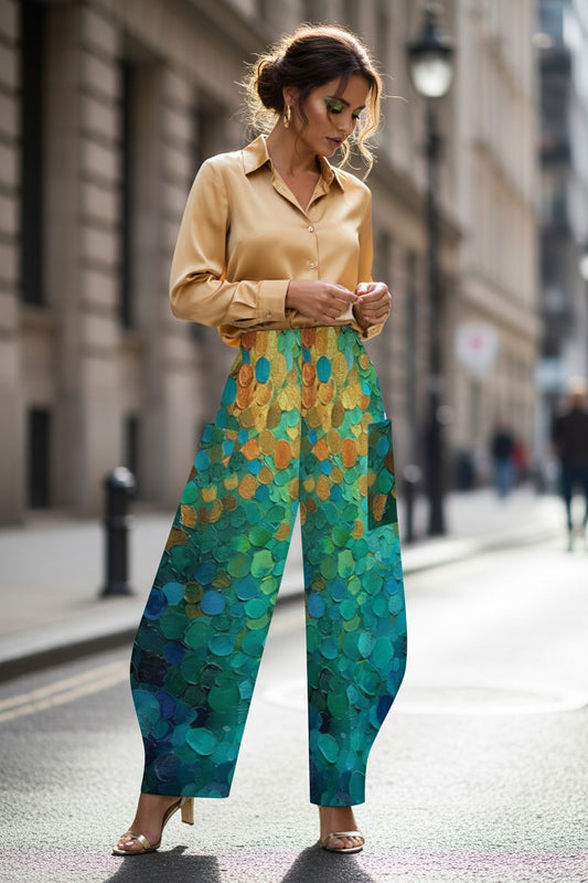 Woman wearing a beige shirt and colorful pants on a city street.