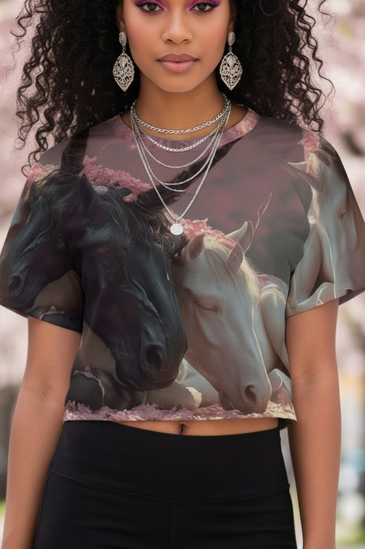 Woman wearing a shirt with horse design, standing outdoors with cherry blossoms in the background.